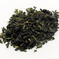 Dry green tea leaves and mint on a white background