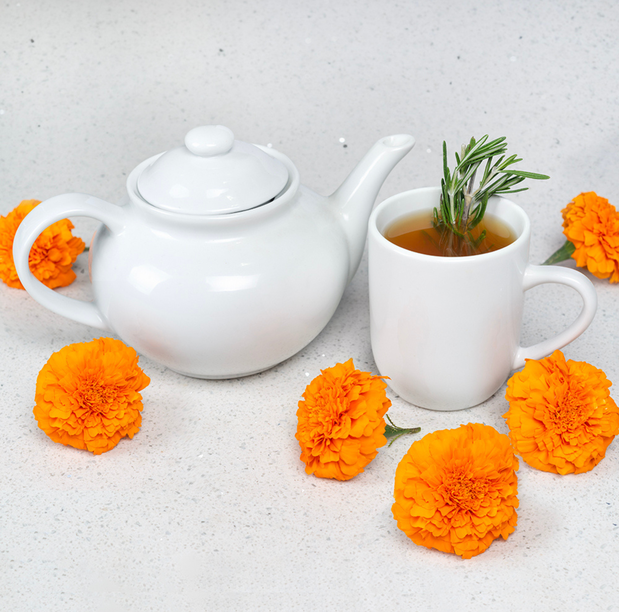 White tea set with marigolds on a white background 